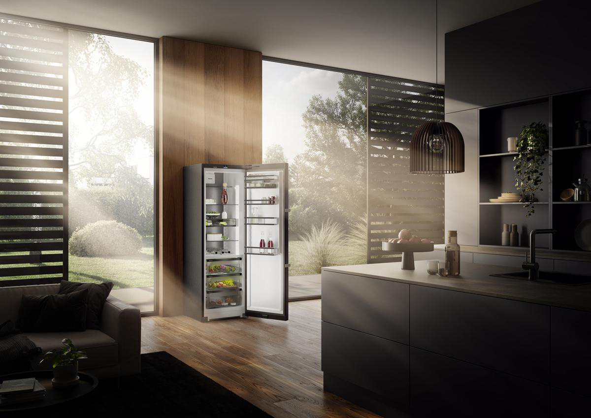 Offener Kühlschrank in einer Küche. Zeigt Regale mit Lebensmitteln. Blick nach draußen durchs Fenster.