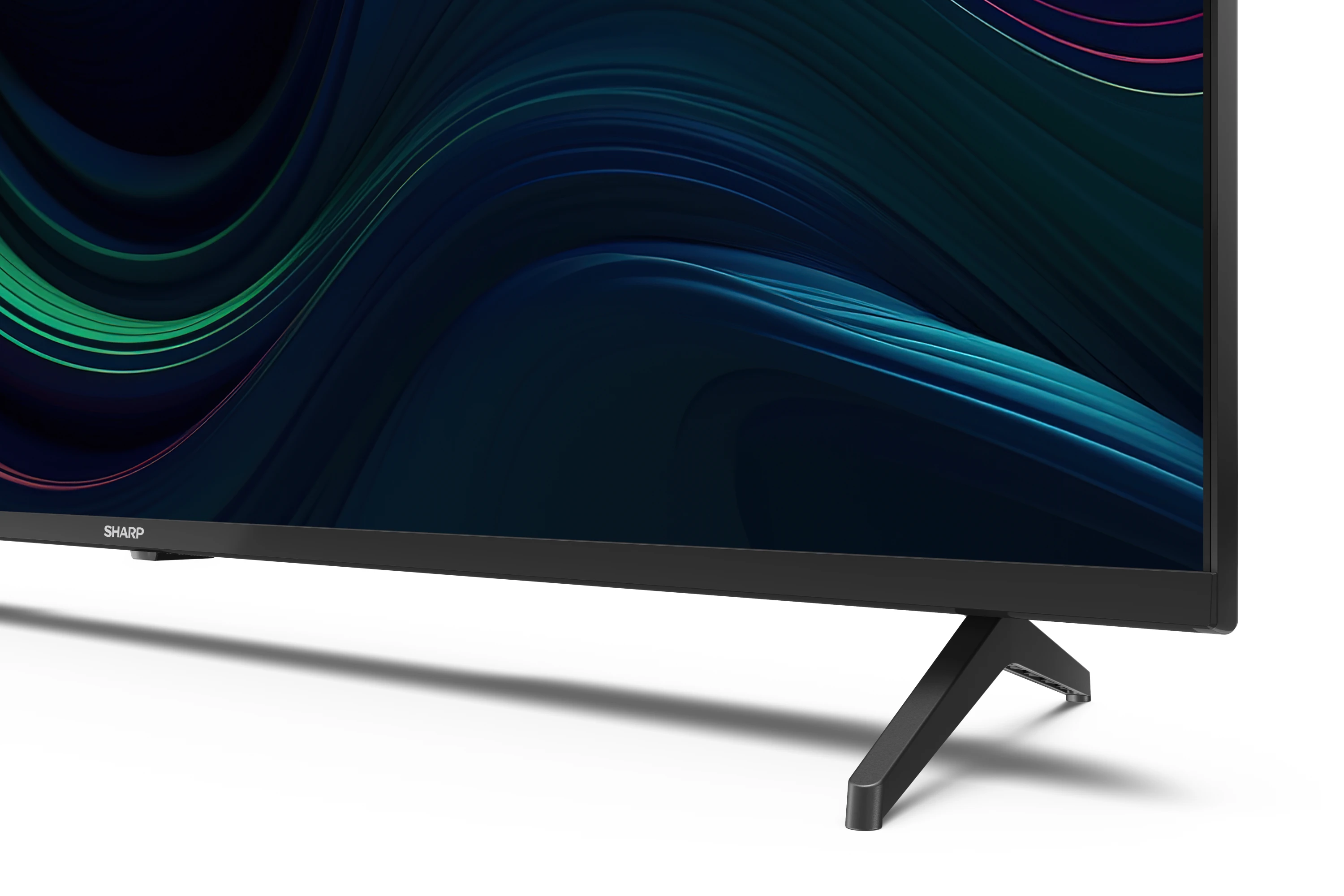 Televisor negro con soporte sobre superficie blanca. La pantalla está oscura.