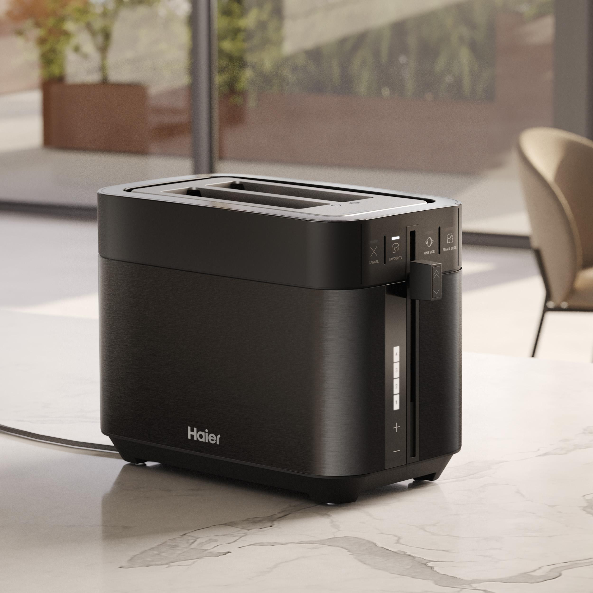 Schwarzer Haier Toaster auf Marmortisch. Knöpfe und Hebel sind sichtbar. Im Hintergrund Fenster und Stuhl.