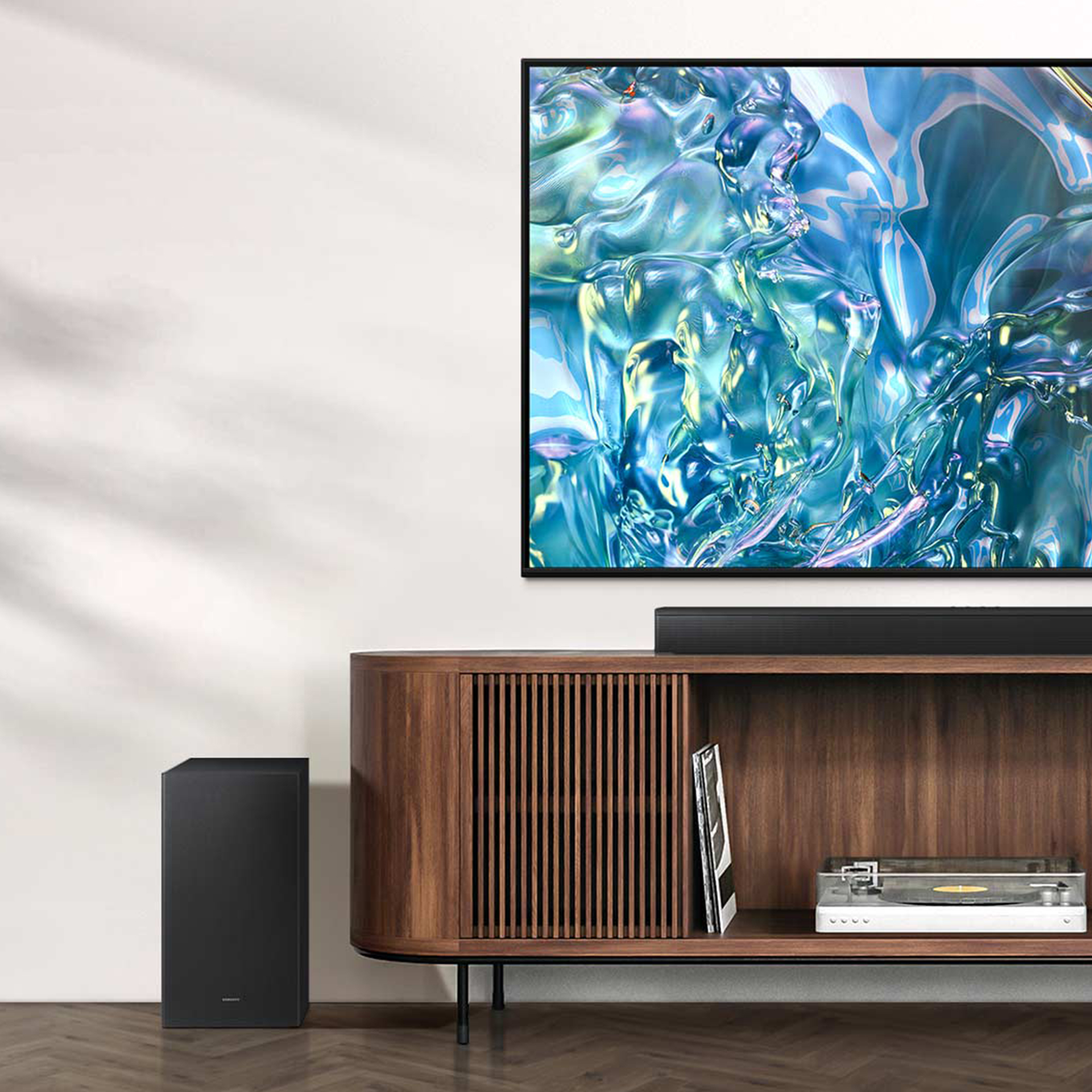 Una configuración de sala de estar con TV, barra de sonido y subwoofer.