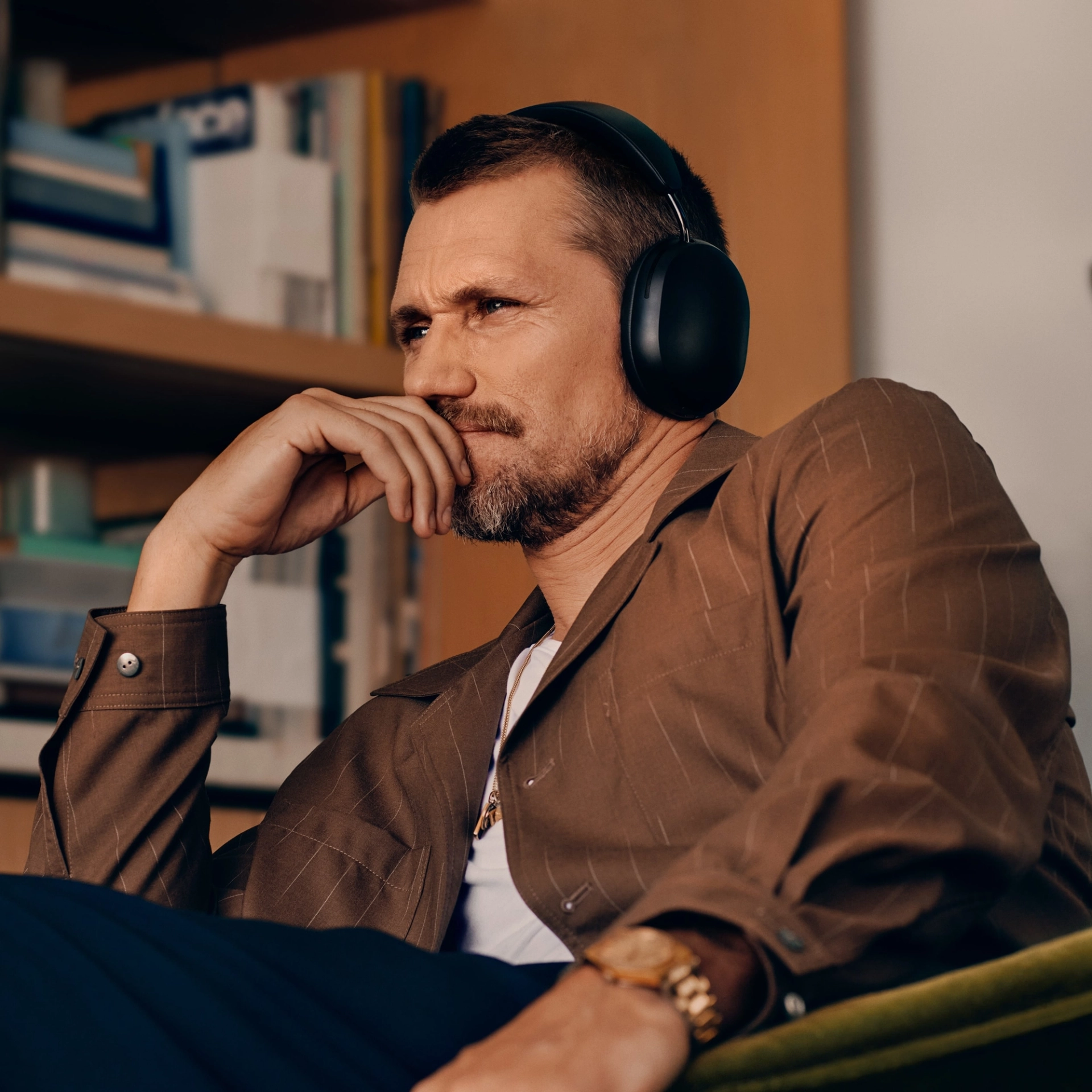 Un homme portant un casque noir, assis et regardant ailleurs, l'air pensif.