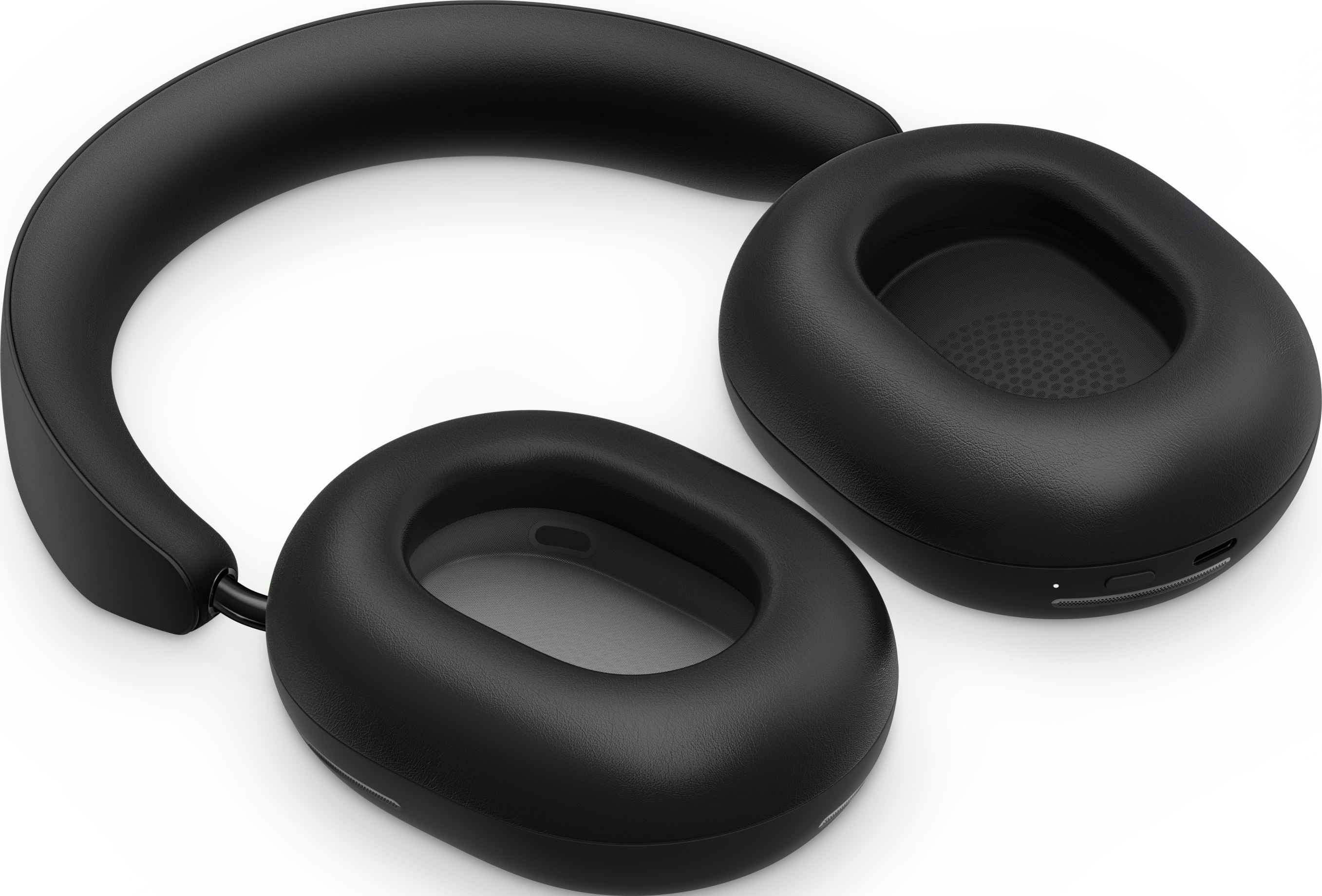 Casque circum-auriculaire noir avec coussinets sur une surface blanche.