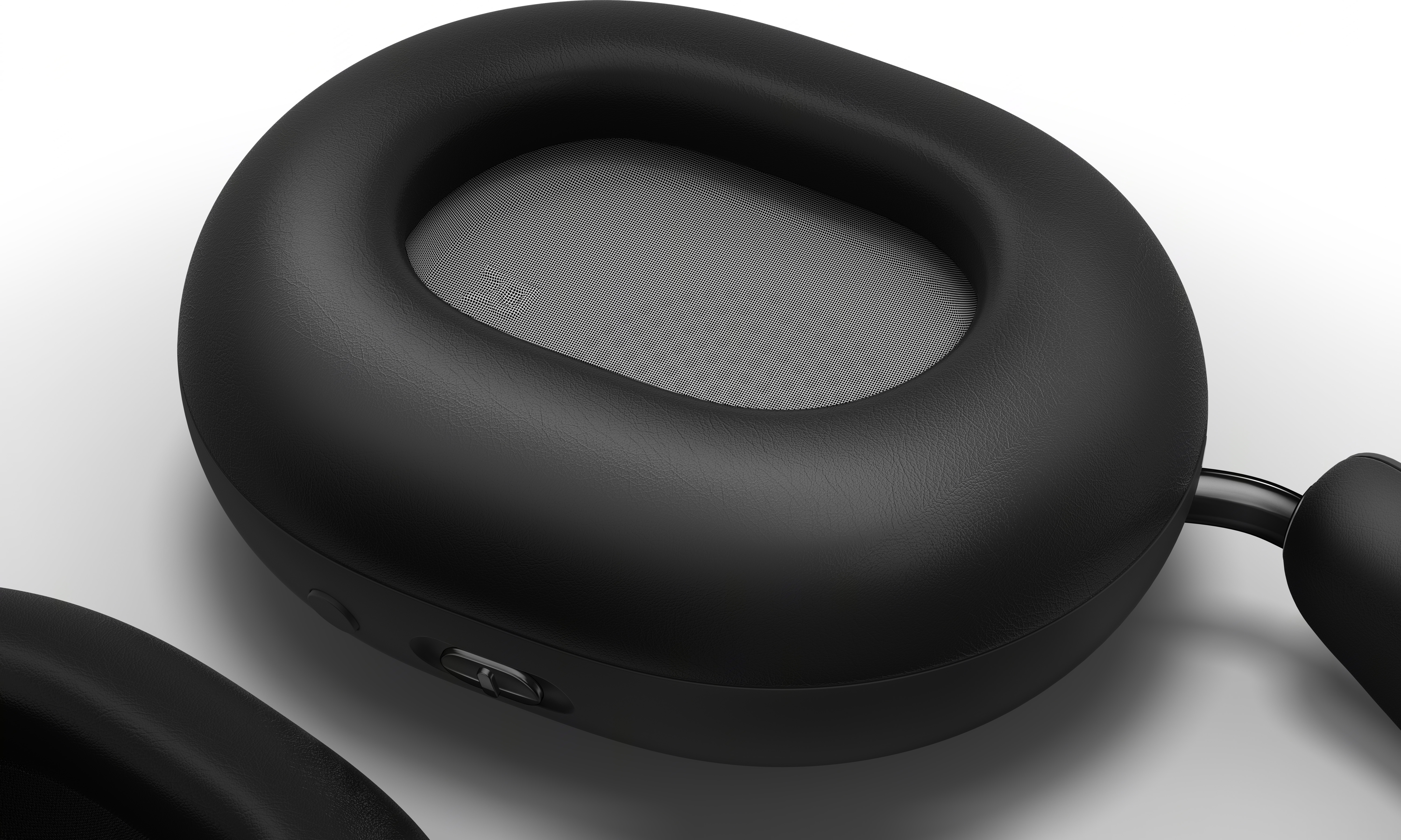 Casque noir, gros plan d'un écouteur avec intérieur gris et bouton.