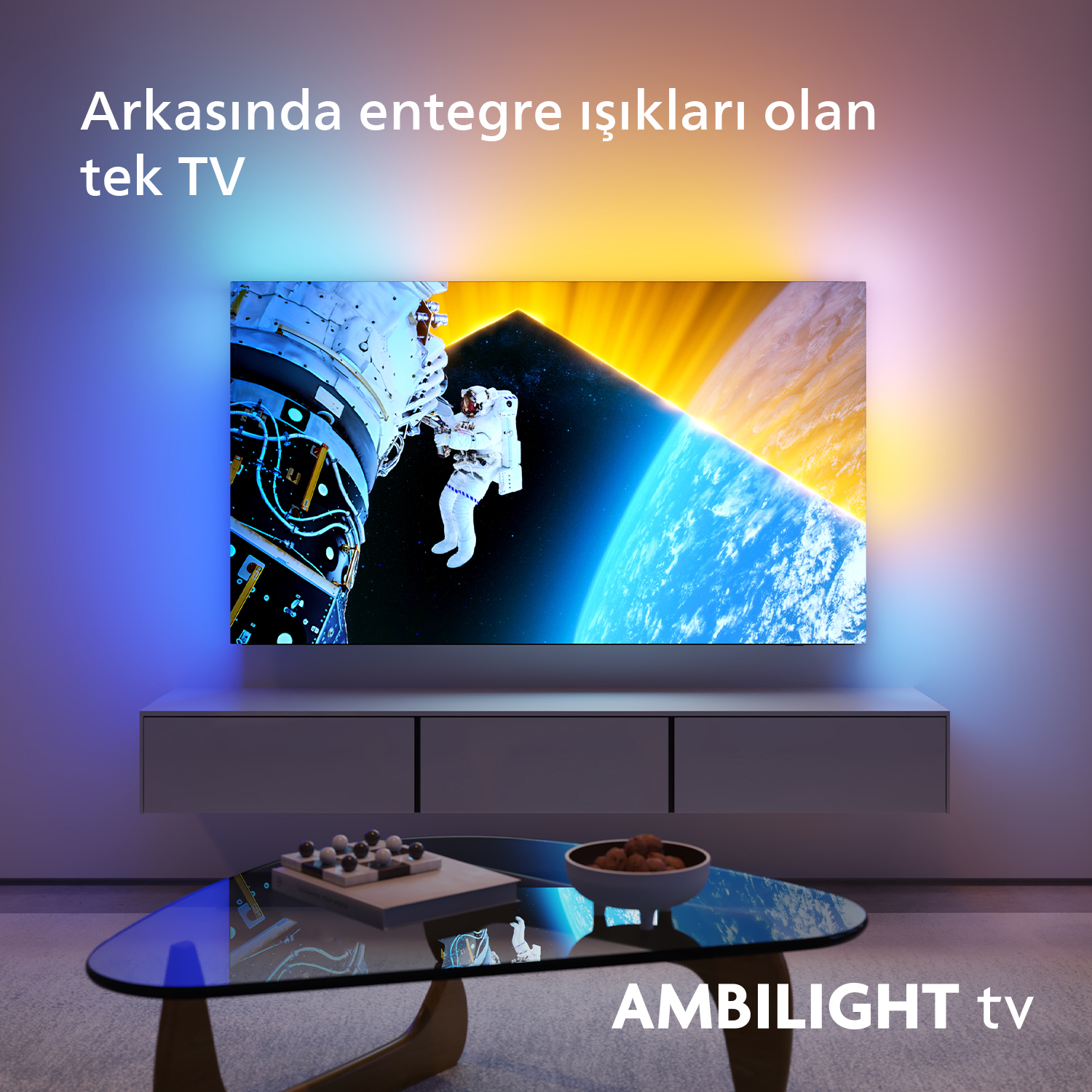 Ekranında astronot olan TV, beyaz dolap üzerinde, cam masa ve Ambilight ile.