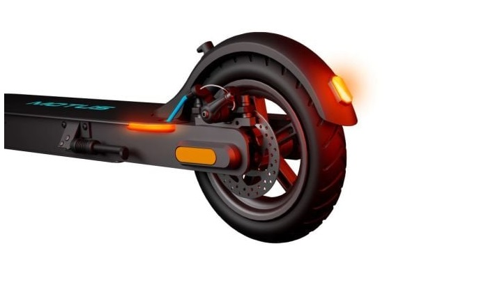 Zbliżenie tylnego koła hulajnogi elektrycznej, z czerwonym światłem i hamulcem tarczowym.