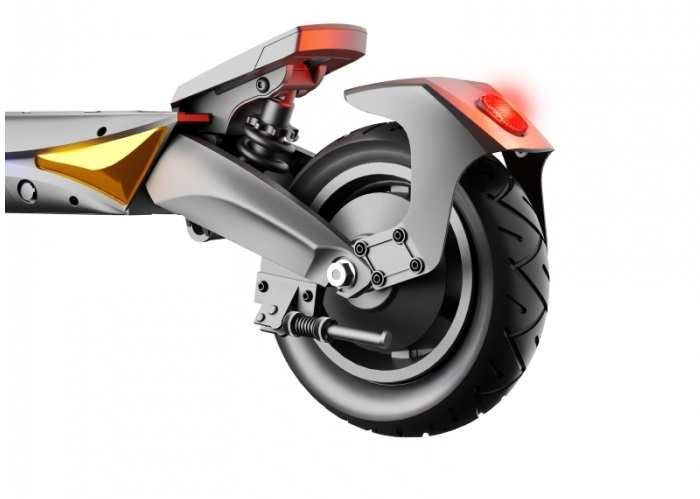 Tylne koło hulajnogi elektrycznej. Widoczne czerwone światło. Czarna opona, srebrne zawieszenie.