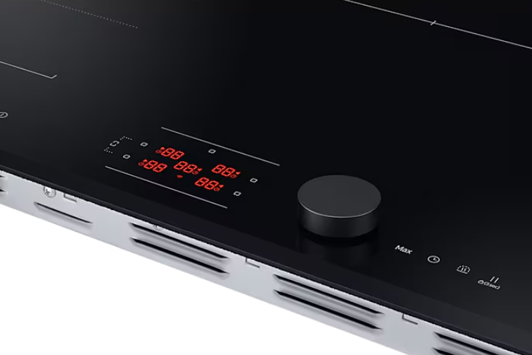Zbliżenie czarnej płyty indukcyjnej z pokrętłem i czerwonymi wyświetlaczami cyfrowymi z liczbami.