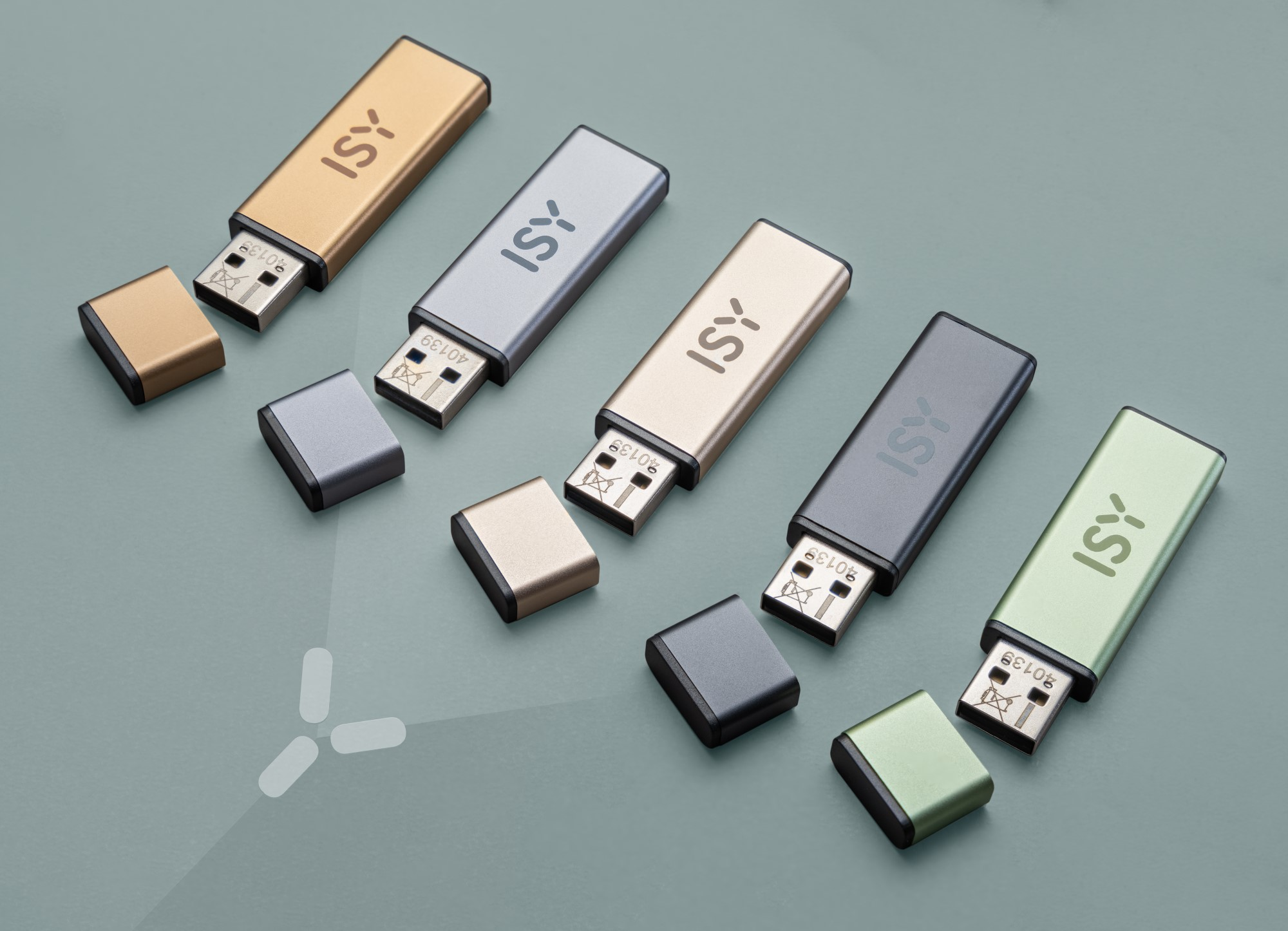 Pięć dysków USB jest ułożonych. Każdy ma metaliczne wykończenie i nasadkę. Na zielonkawej powierzchni.