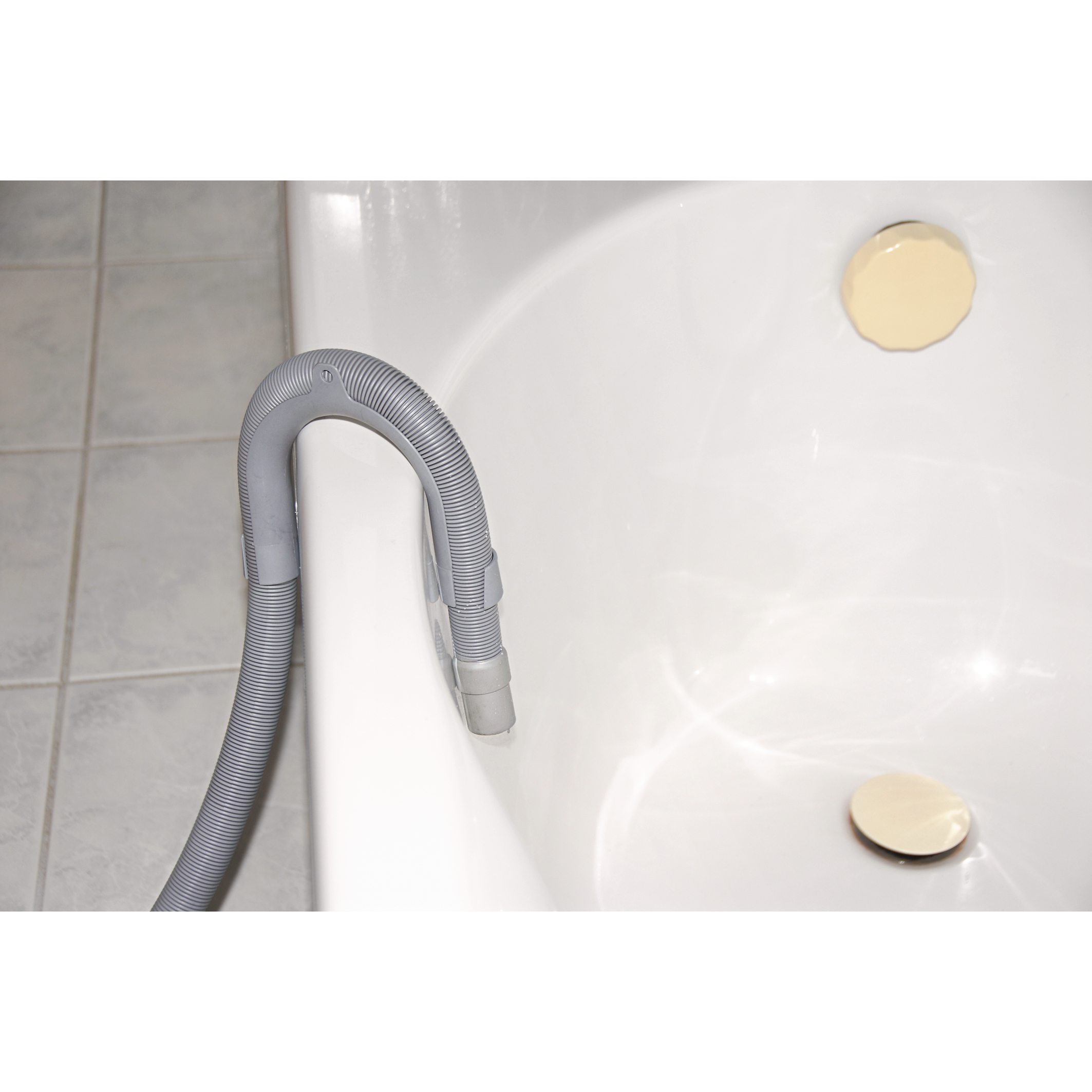 Ein grauer Schlauch ist an einer weißen Badewanne befestigt. Zwei beige Kreise befinden sich auf der Wanne.