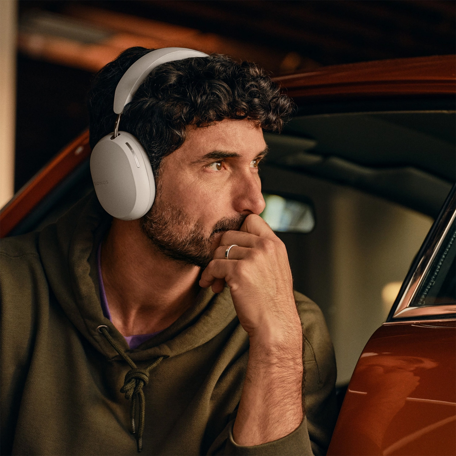 Uomo con le cuffie, che guarda altrove, probabilmente ascoltando musica in auto.