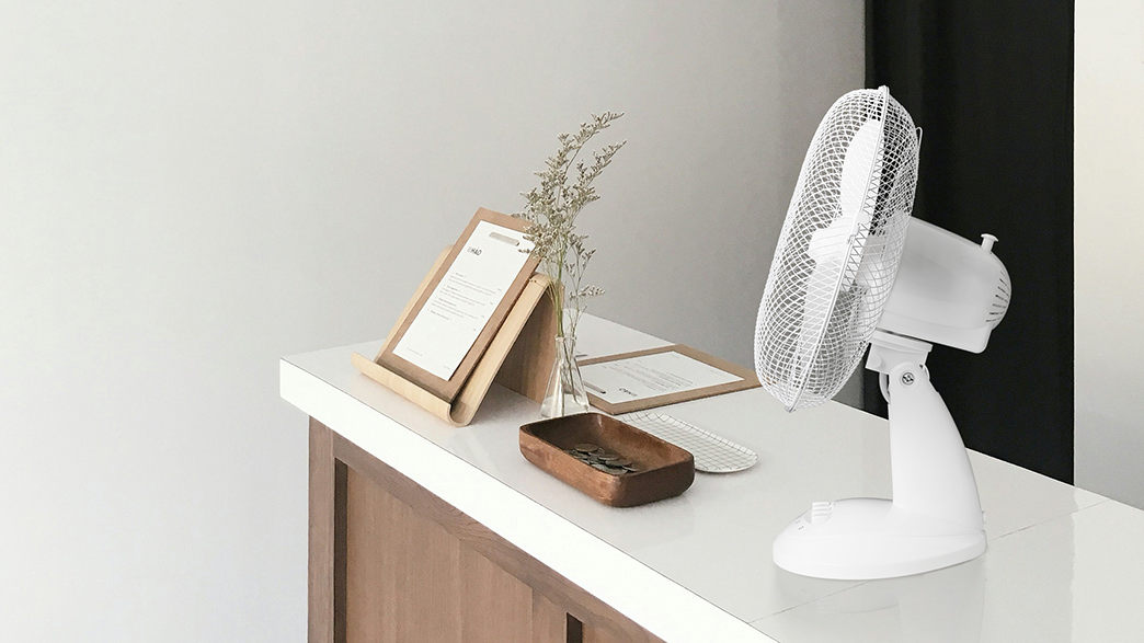 Egy fehér ventilátor egy fehér pulton, menükkel és dekorációkkal.