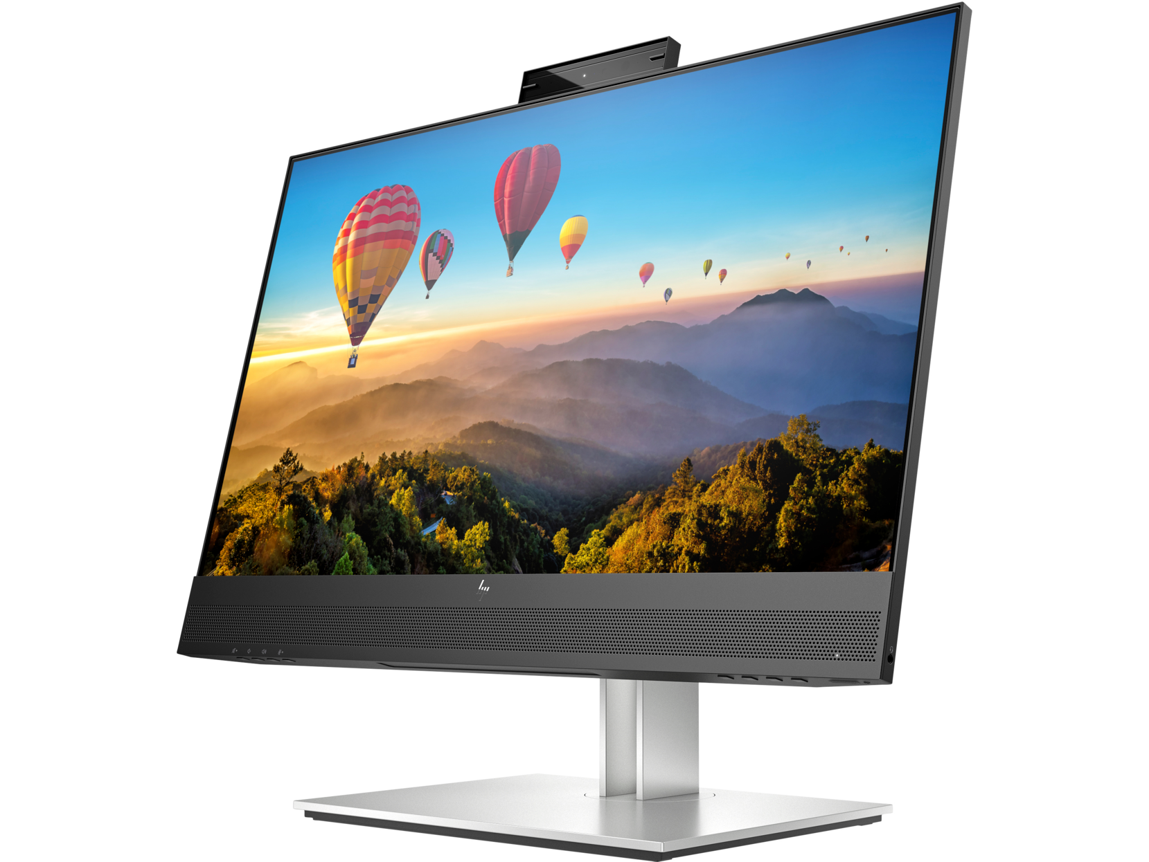 Un monitor de computadora grande mostrando un paisaje colorido con globos aerostáticos. Una webcam encima.