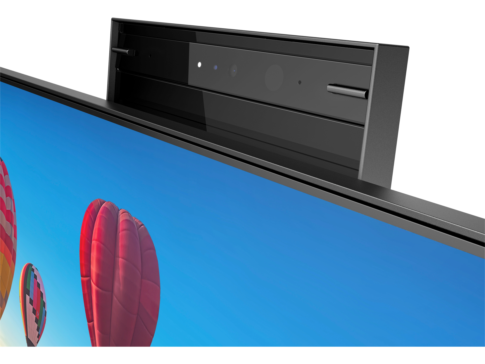 Primer plano de un monitor negro con barra de cámara arriba, mostrando cielo azul y globos aerostáticos.