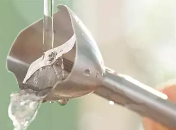 Ostrze blendera ze stali nierdzewnej spłukiwane wodą. Widoczne krople wody.