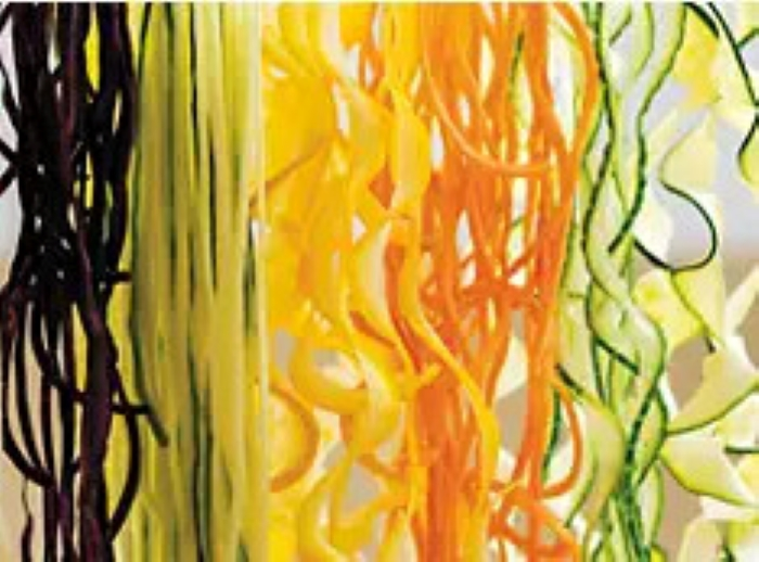 Zbliżenie kolorowych spiral z warzyw: fioletowy, zielony, żółty i pomarańczowy.