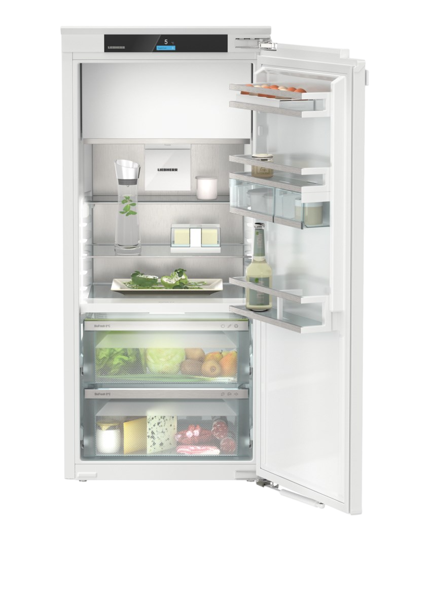 Weißer Kühlschrank mit offener Tür, gefüllt mit Lebensmitteln. Weißer Hintergrund. Modernes Küchengerät.