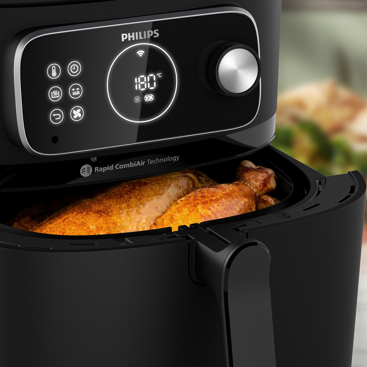 Black air fryer with a cooked chicken inside and digital control panel.