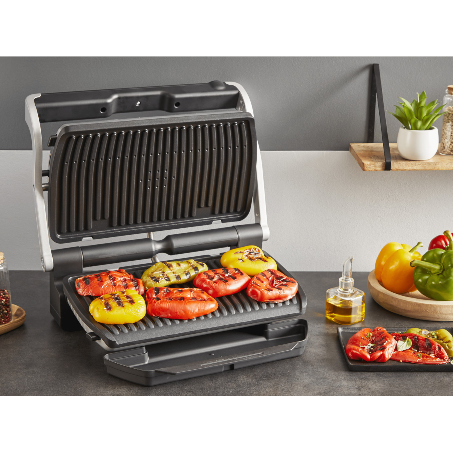 Grill with grilled peppers and oil bottle.