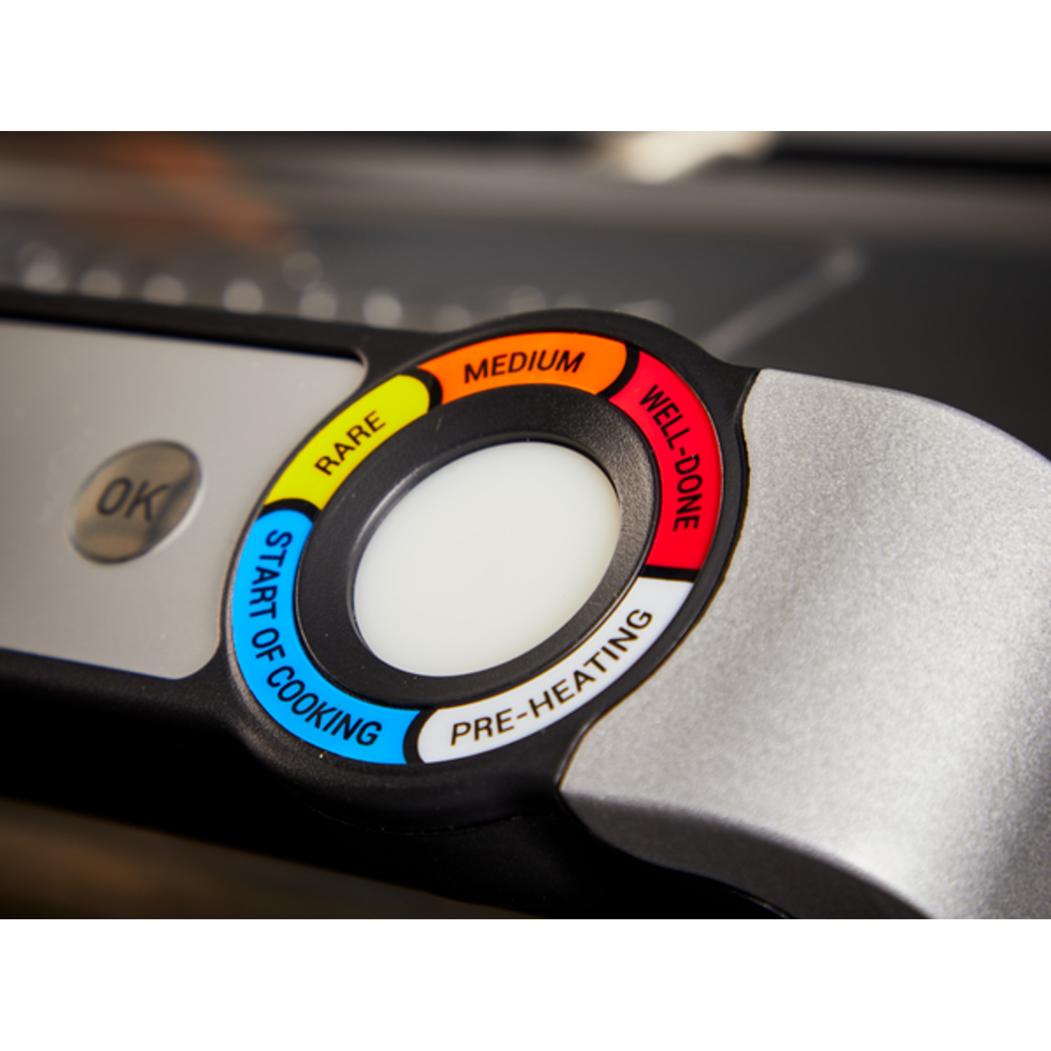 Close-up of a food thermometer showing temperature zones: rare, medium, well-done.