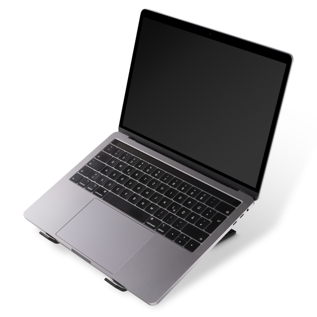 Laptop en un soporte, abierto, color gris. Teclado y pantalla negros. Fondo blanco.
