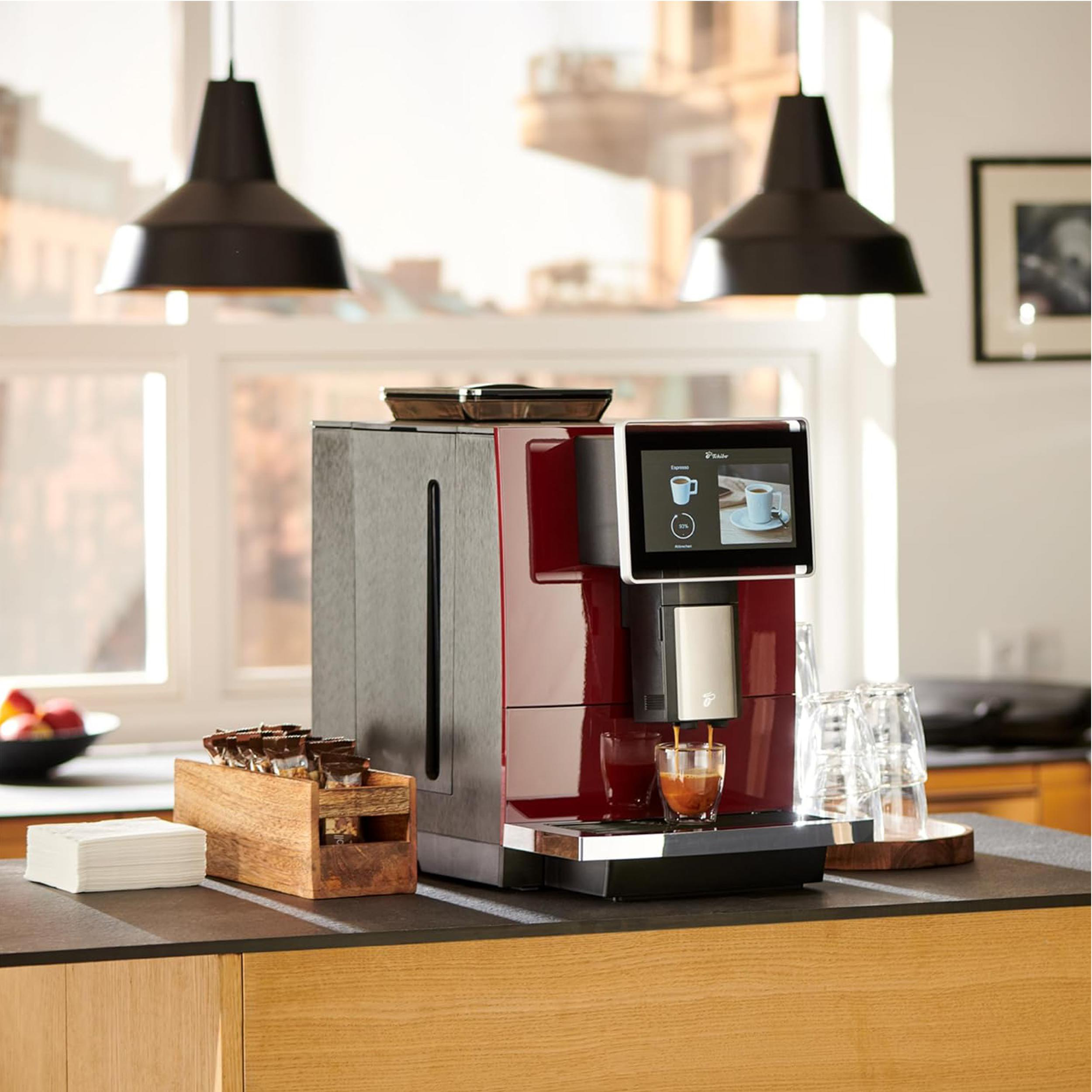 Kaffeemaschine mit Touchscreen, eine Tasse wird gefüllt, und ein Holzhalter.