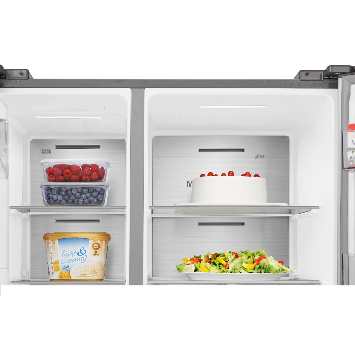 Inside a refrigerator: berries, a cake, and salad on shelves, ice cream below.