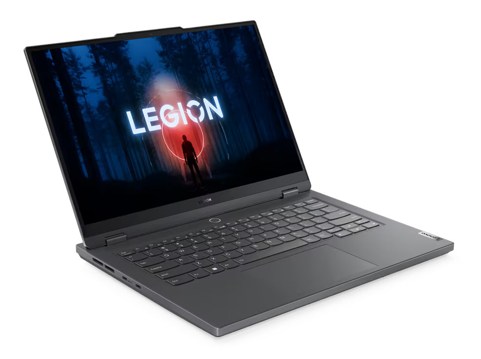 Laptop z ciemnoszarą obudową, otwarty, pokazujący świecący napis 'LEGION' na tle lasu.