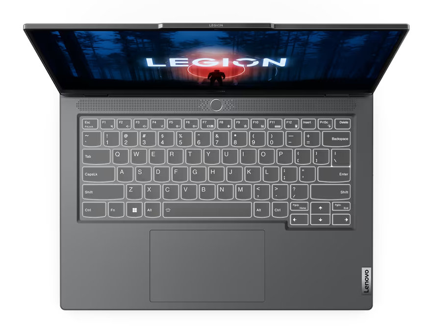 Laptop z góry z podświetlaną klawiaturą i grafiką na ekranie. Szary i otwarty.