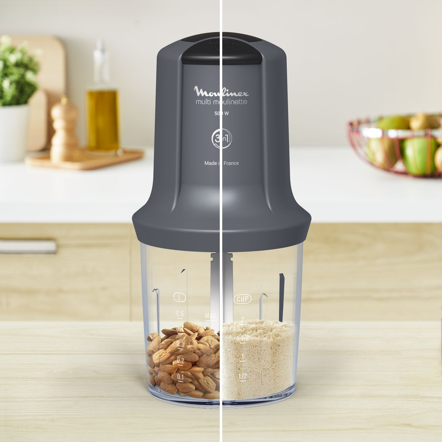 Gray and clear food processor filled with almonds and chopped food.  Moulinex brand on it.