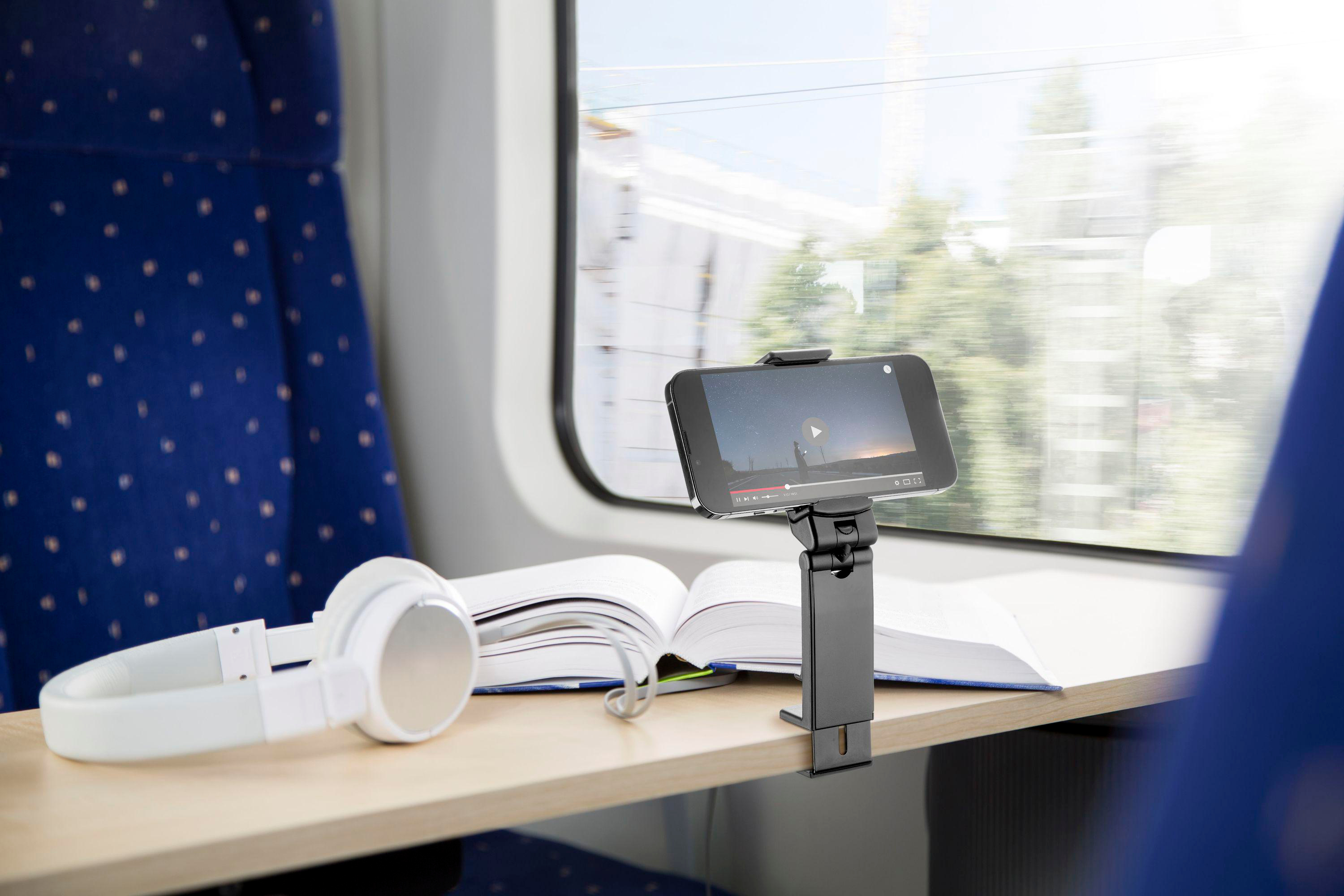 Smartphone auf Ständer auf einem Zugtisch, spielt ein Video ab.