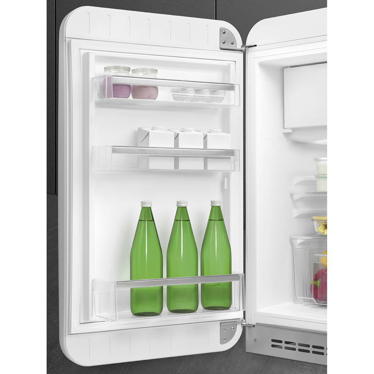 Ein weißer Smeg-Kühlschrank mit offener Tür, zeigt Regale mit Lebensmitteln und Wasserflaschen.