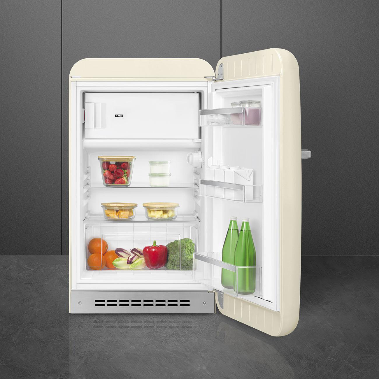 Geöffnete cremefarbene Retro-Kühlschrank, gefüllt mit Lebensmitteln.