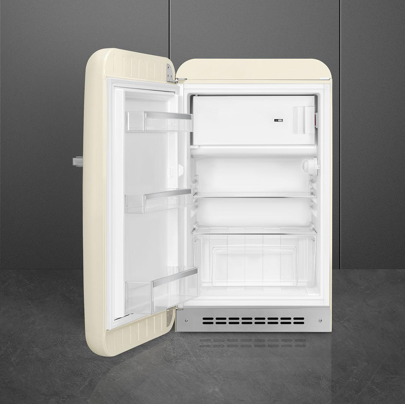 Beiger Retro-Kühlschrank mit offener Tür. Innenraum sichtbar. Dunkler Hintergrund.