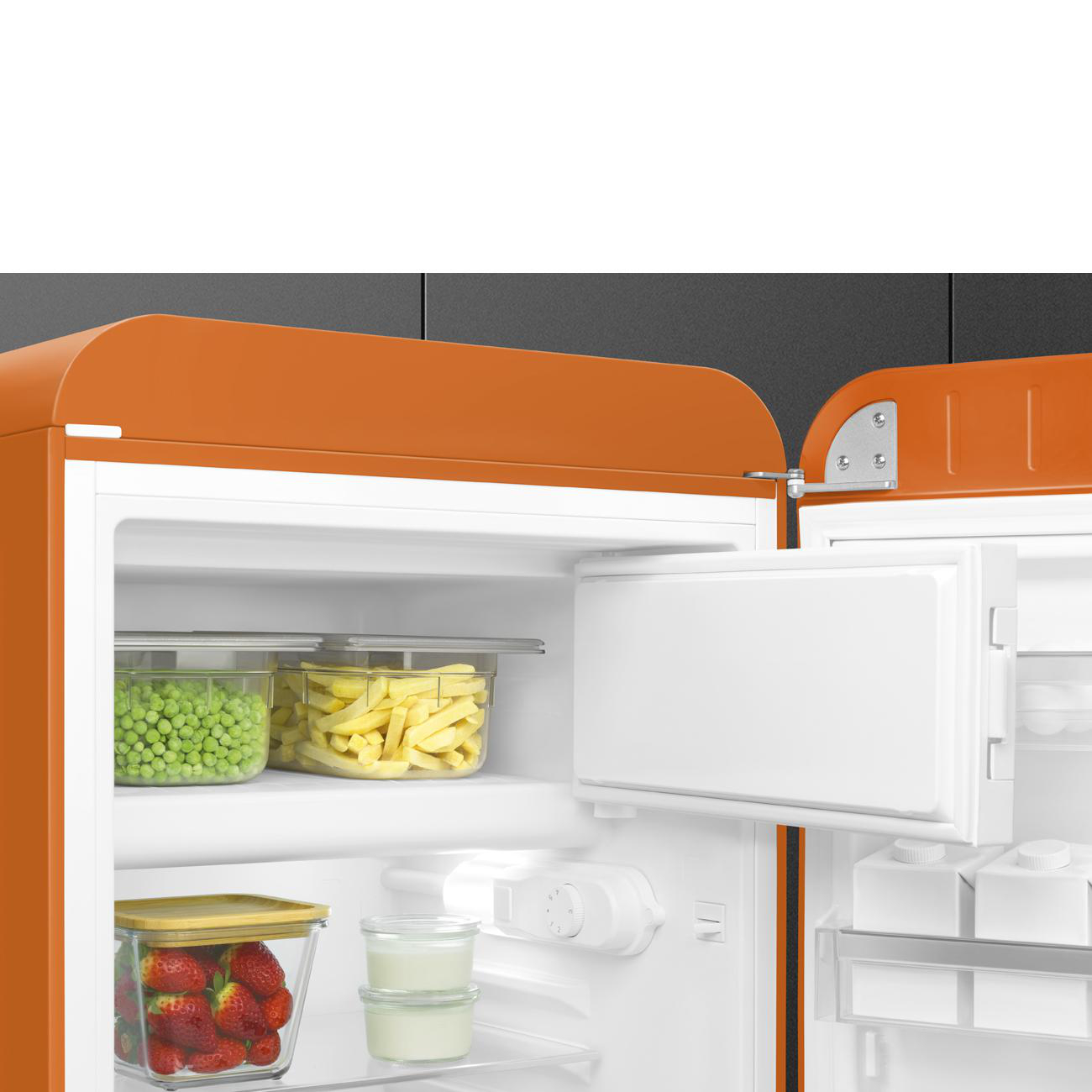 Oranger Retro-Kühlschrank mit geöffneter Tür, zeigt den Innenraum mit Lebensmitteln.