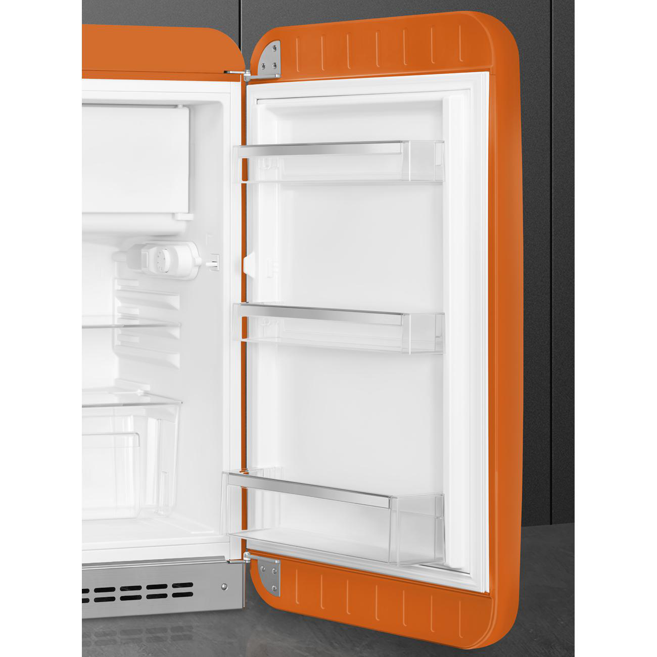 Oranger Smeg-Kühlschrank mit offener Tür, Innenraum mit Regalen und kleinem Fach.