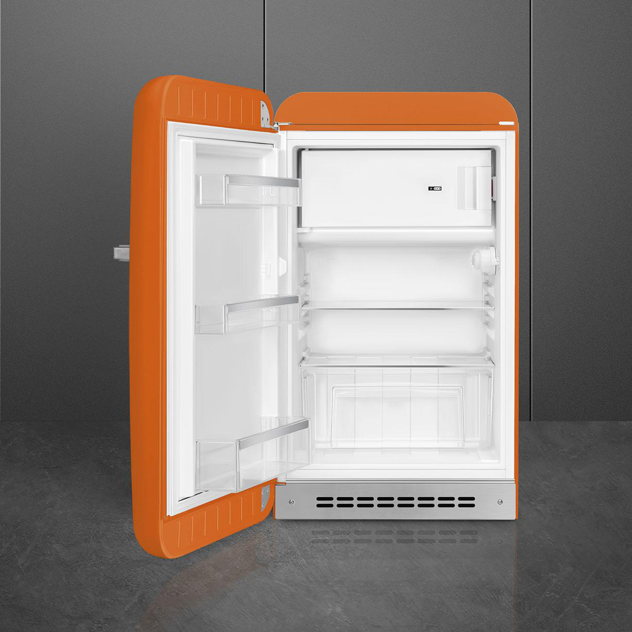 Ein orangefarbener Kühlschrank im Retro-Stil mit offener Tür, der das Innere mit weißen Regalen zeigt.