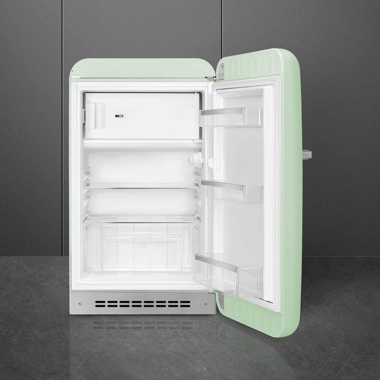 Ein hellgrüner Retro-Kühlschrank mit offener Tür, der Innenregale und ein Gefrierfach zeigt.