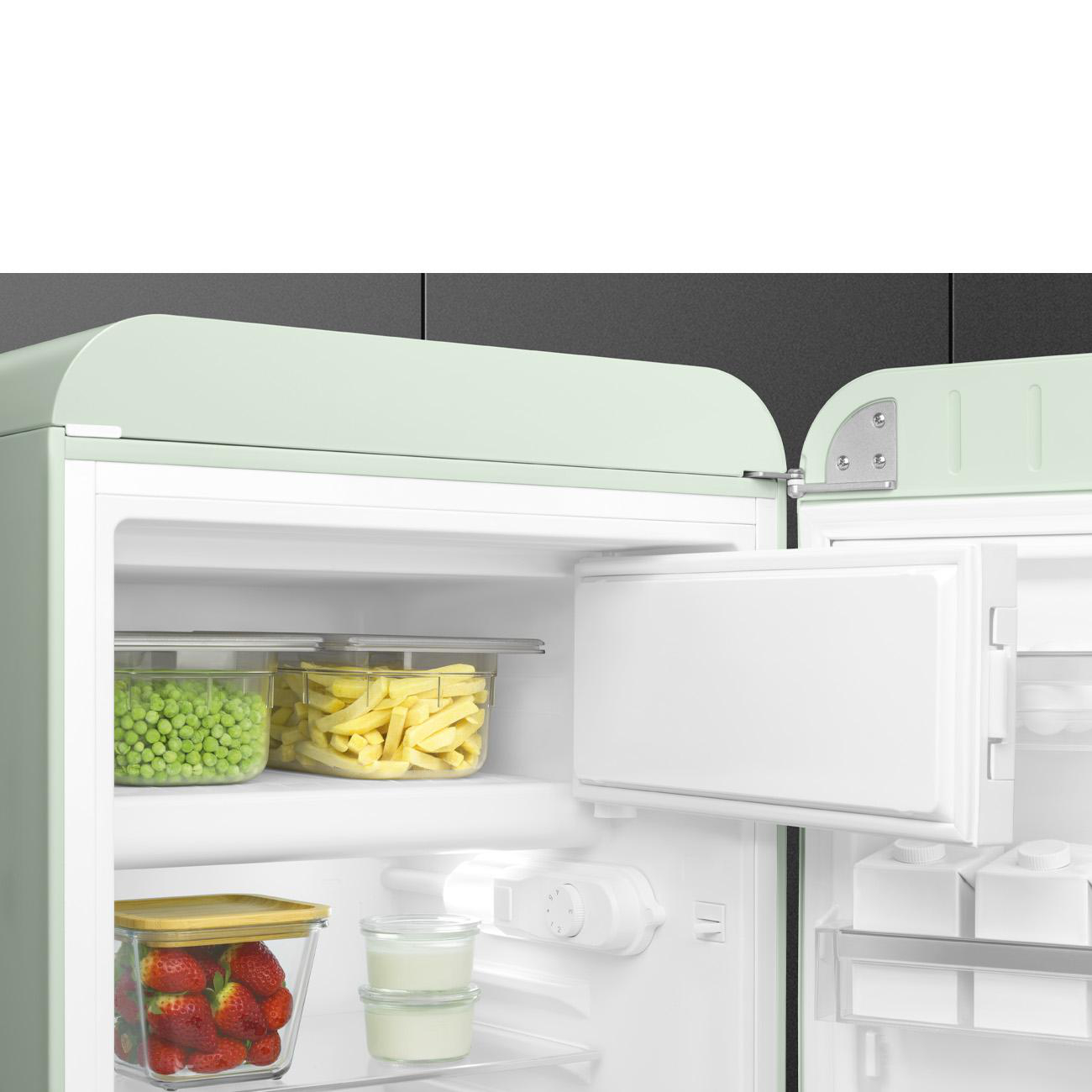 Ein grüner Kühlschrank mit weißem Innenraum, offener Tür und Lebensmitteln.