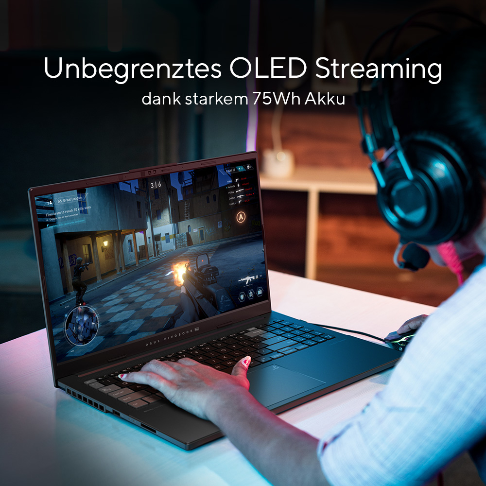Person, die einen Laptop benutzt, ein Spiel spielt, mit einem Headset.