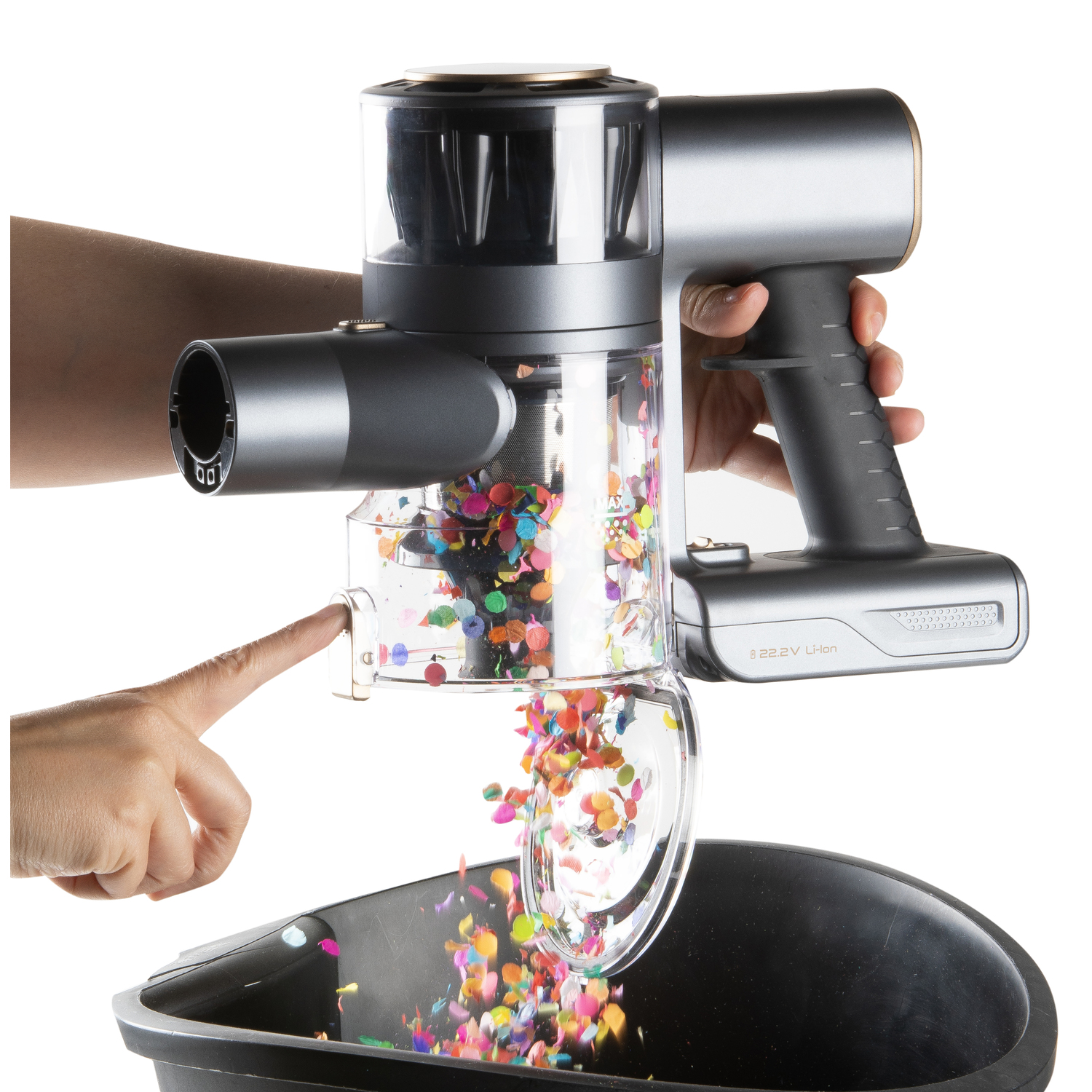 Main tenant un aspirateur sans fil, des confettis tombant dans une poubelle.