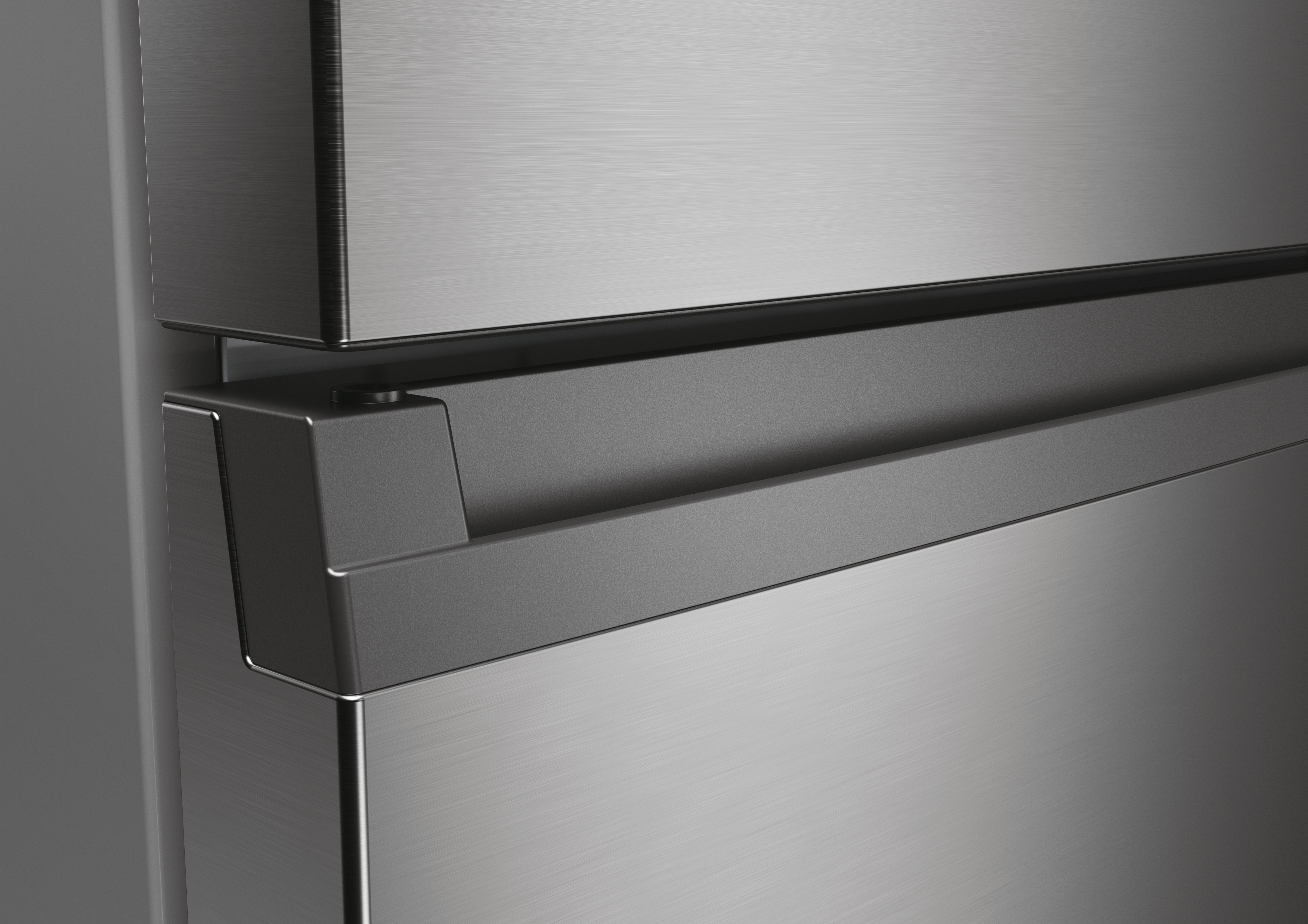 Primer plano de un tirador de refrigerador gris metálico en una puerta de refrigerador moderna.