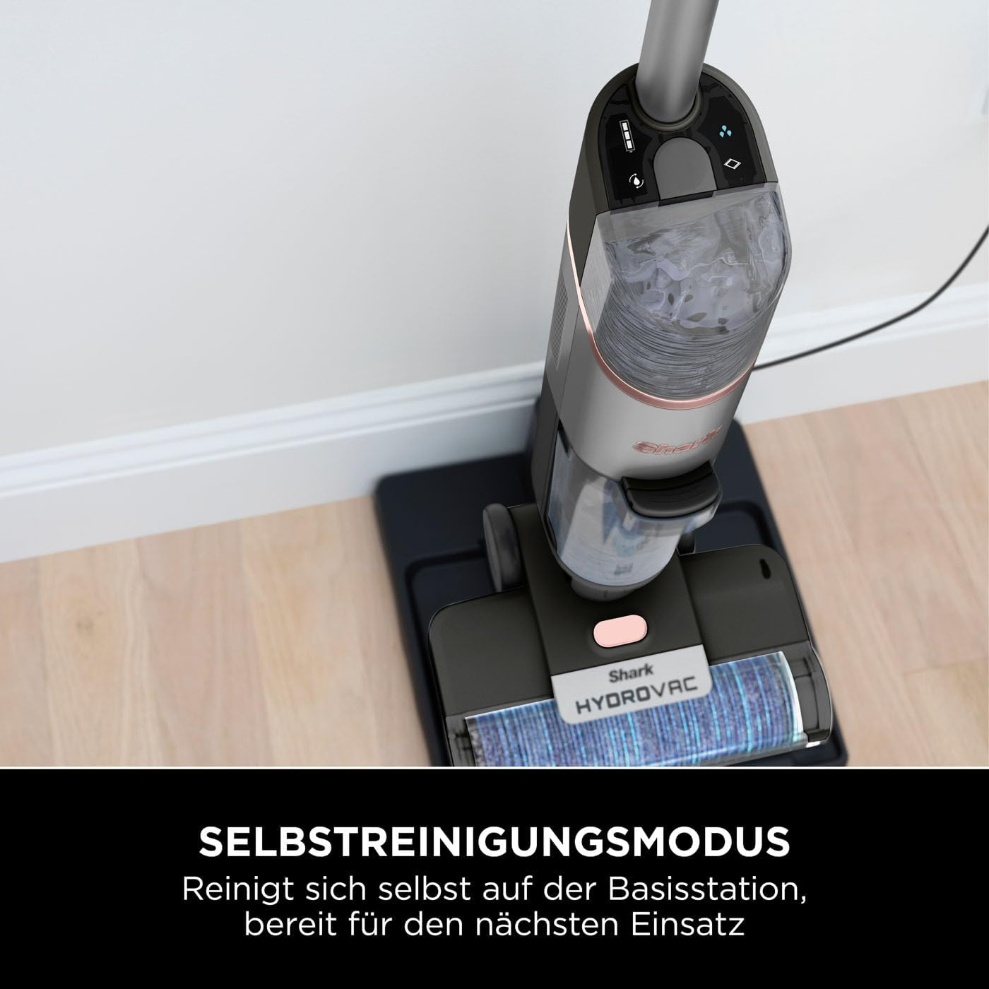 Un aspirateur robot noir et gris sur une station de charge noire, vue rapprochée.