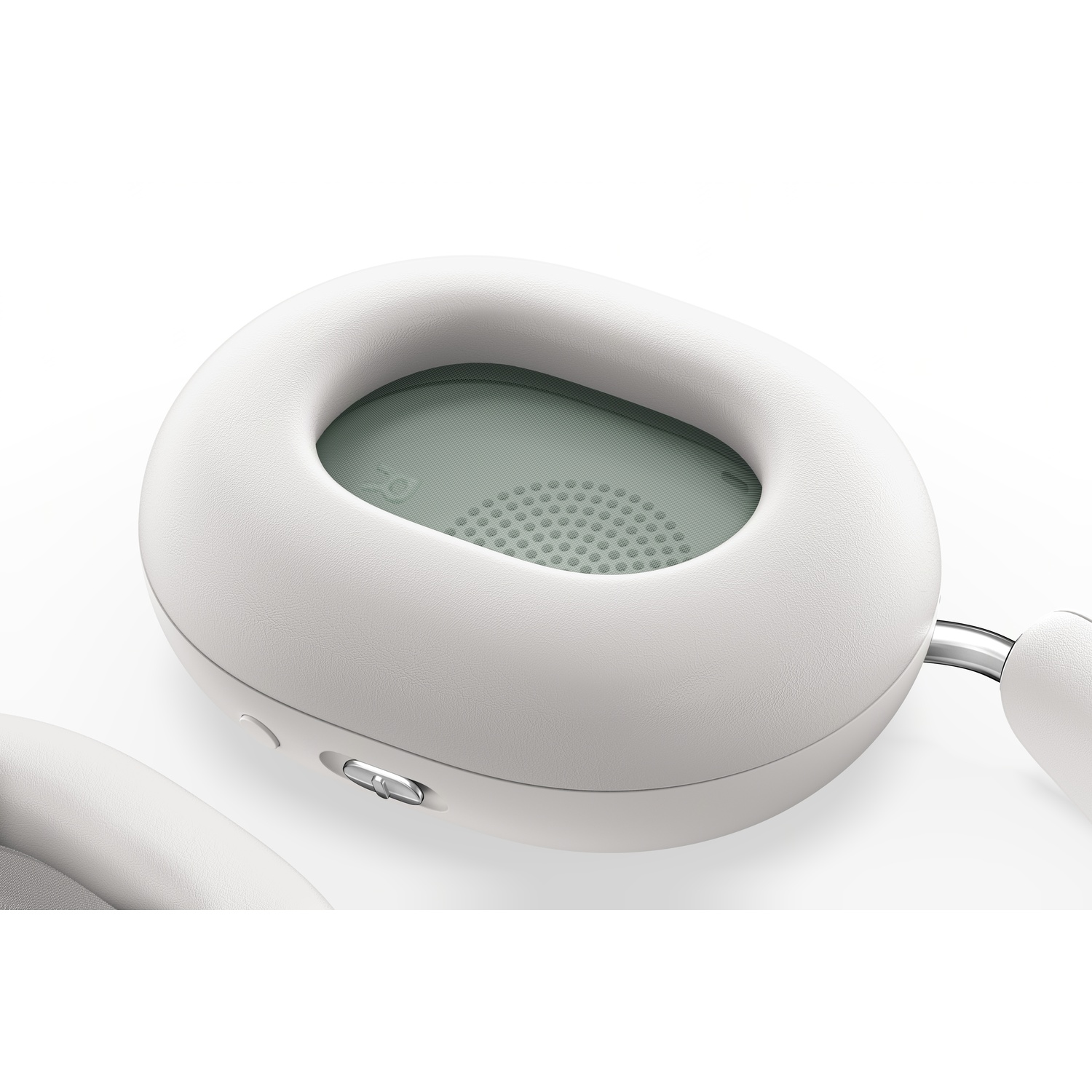 White headphones showing ear cup detail with a silver button and a mesh.