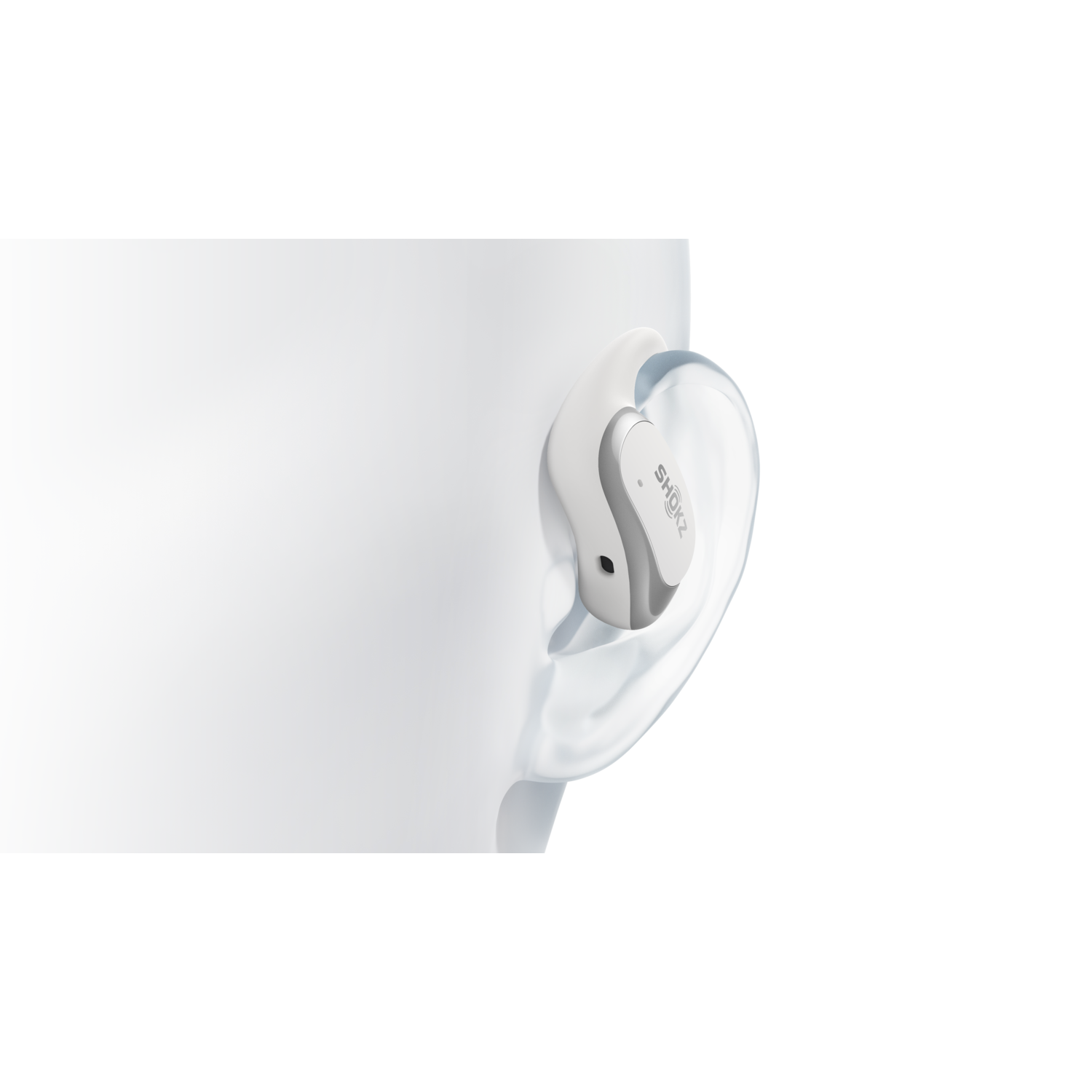 White Shokz earbud in ear, with a white background.
