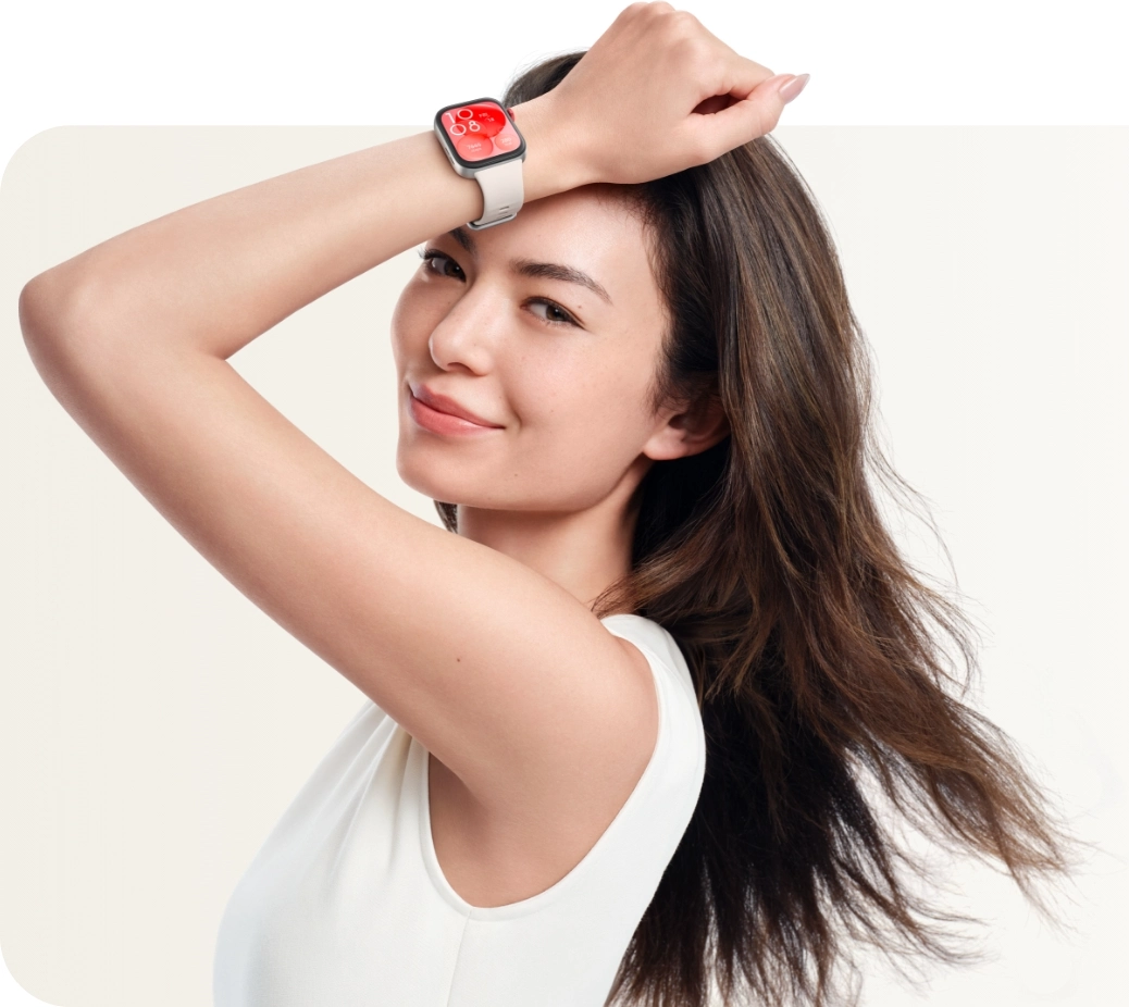 Eine Frau lächelt, trägt eine Smartwatch am Handgelenk, mit weißem Hintergrund.