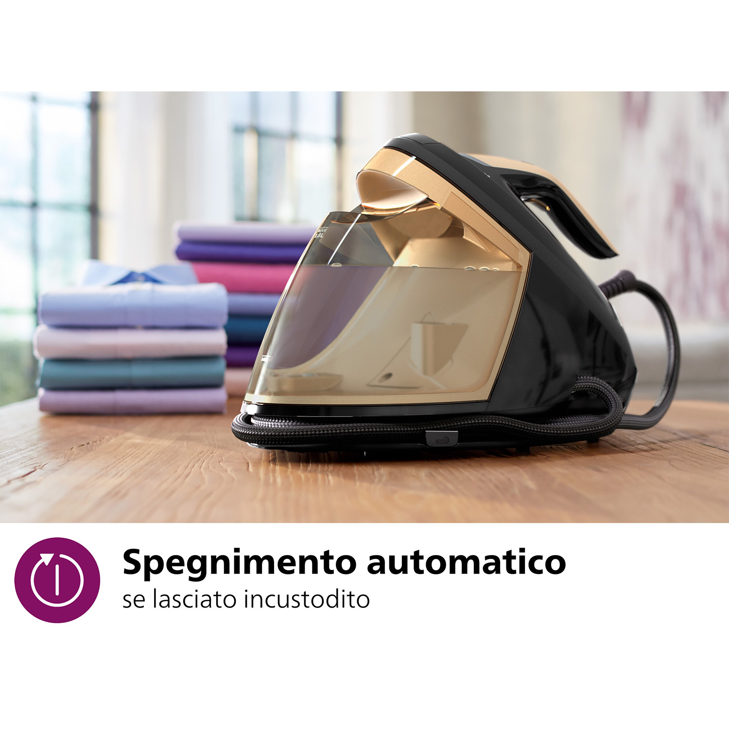 Un ferro da stiro nero e oro con un serbatoio dell'acqua e una pila di vestiti.