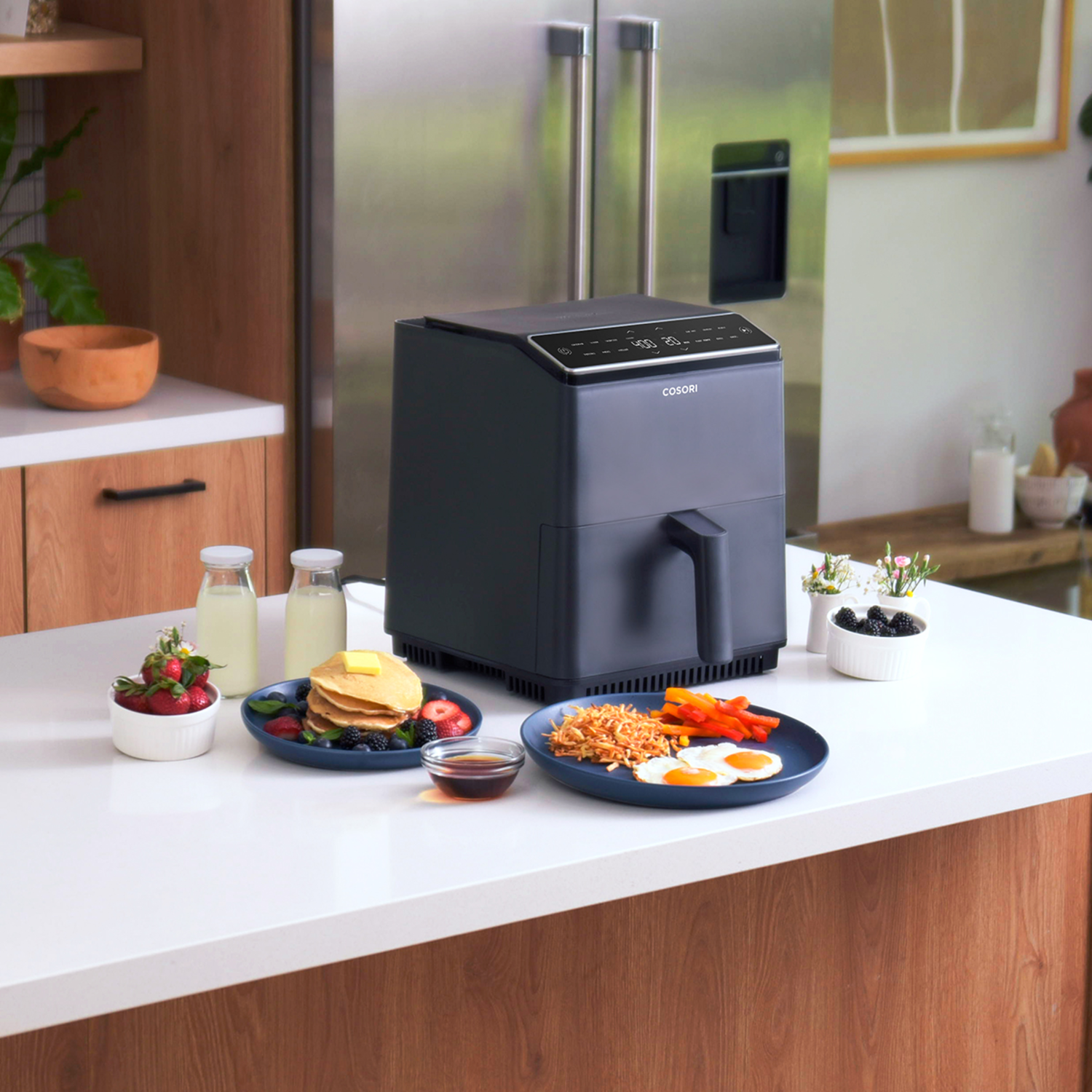 Een airfryer met eten op het aanrecht.