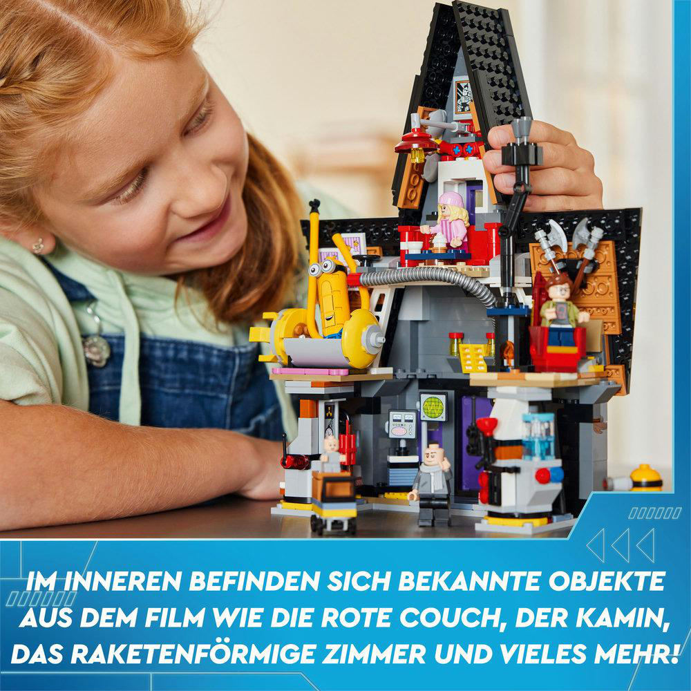 Ein Kind betrachtet ein Lego-Set eines Spukhauses mit Figuren und Objekten.