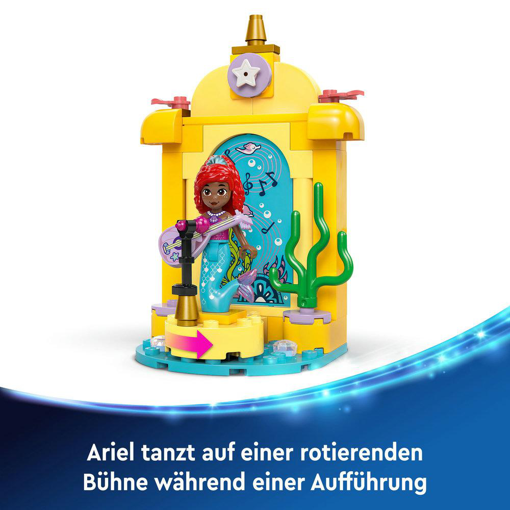Ariel Lego-Figur auf einer Bühne, spielt Gitarre. Gelbe Struktur mit Noten.