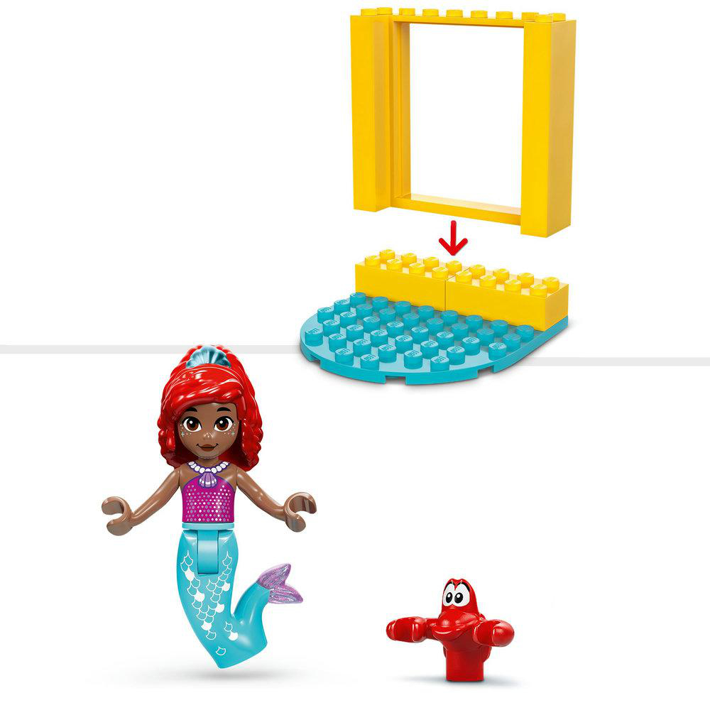 Ariel-Figur, eine rote Krabbe und Bausteine ​​auf weißem Hintergrund.